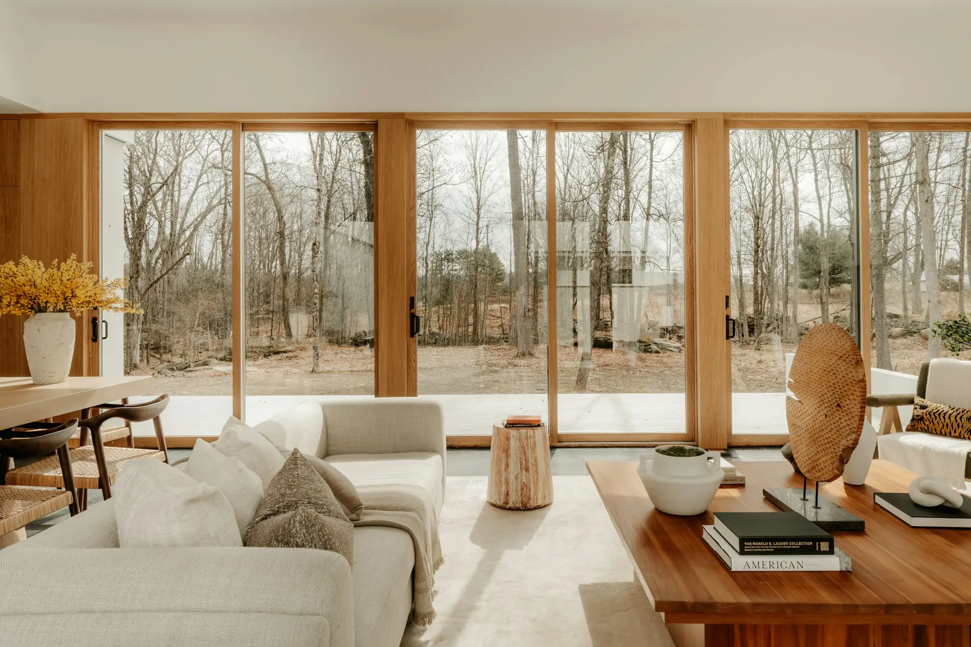 Bright living room with a full wall of sliding glass doors looking out to trees